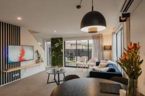 a living room with a couch and a table at Travellers' dream steps from shops and close to Airport in Christchurch