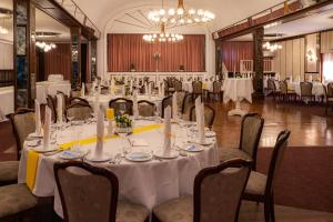 a conference room with a table and chairs with white table cloth at Hotel Zur Post in Neubruchhausen