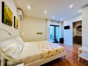 YourHome - A Casa di Manuela في سانتّانييلّو: غرفة نوم بسرير في غرفة بها تلفزيون