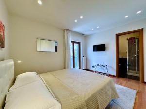 YourHome - A Casa di Manuela في سانتّانييلّو: غرفة نوم بها سرير وتلفزيون على الحائط