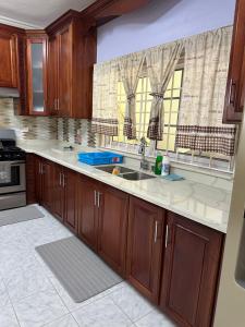 a kitchen with wooden cabinets and a sink at Villa Azure in Tower Isle