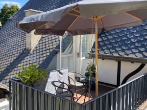 un patio con una mesa y una sombrilla en una casa en Weingut Krupka Riverside, en Kröv