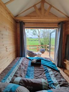a bed in a room with a large window at Riverside cabin in Limerick