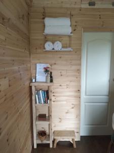 a room with a wooden wall with a book shelf at Riverside cabin in Limerick
