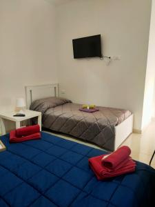 a bedroom with two beds and a flat screen tv at Bed and fly Aeroporto Catania in Catania