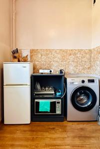 a kitchen with a microwave and a refrigerator and a washing machine at City Center in Ulaanbaatar