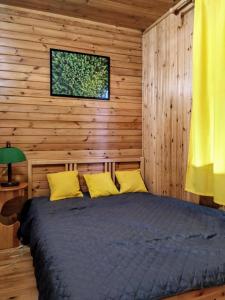 a bedroom with a bed in a wooden cabin at Dom Pilchy nad jeziorem Roś in Pilchy