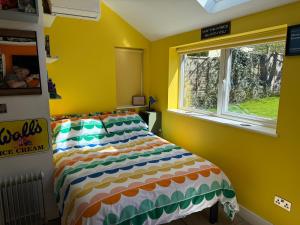 a bedroom with a bed in a yellow room with a window at Cherry Cottage Retro Stay, Stourport-on-Severn in Stourport