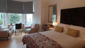 a hotel room with a bed and a table and chairs at Antler Guest House in Edinburgh