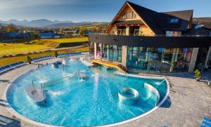 a large swimming pool in front of a house at Mountain View Apartament Termy Chochołowskie 5 min in Suchá Hora