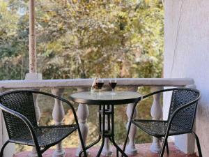 two glasses of wine sitting on a table on a porch at Achi Guest House in Makhinjauri