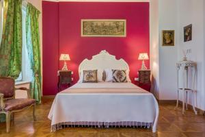 a bedroom with a white bed and a red wall at IPEKYOL Guesthouse in Çeşme