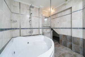 a bathroom with a white tub and a shower at Althea in Skala Potamias +33 photos