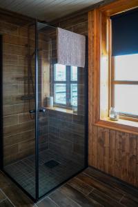 a shower with a glass door in a bathroom at Heimbrygga Restaurant & Accommodation in Skrova