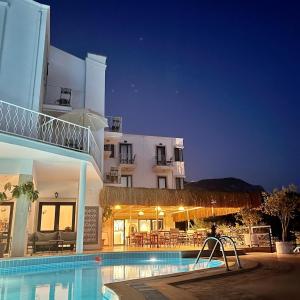 a swimming pool in front of a building at night at The Bay View Boutique Hotel Kalkan in Kas