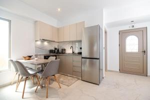 a kitchen with a table and a stainless steel refrigerator at The Azure Suites in Haraki