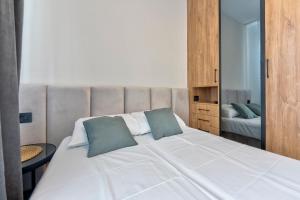 兹拉蒂博尔Modena Resort Spa & Wellness Zlatibor的卧室里有一张白色的大床，上面有两个枕头