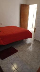a red bed in a room with a tile floor at El depto de Esther 2 in Tandil