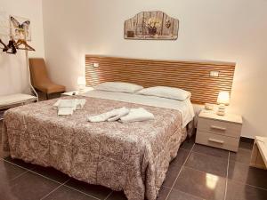 莱切Dimore di Lecce - La Corte的卧室里有一张床，床上放着两条毛巾。 更多118张照片