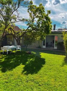 a yard with a table and a bench in front of a house at Individual Guest House - Between Paris and Disneyland in Vaires-sur-Marne