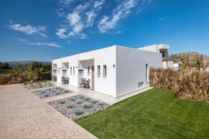a white house with a green lawn at The Azure Suites in Haraki