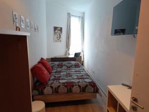 a small bedroom with a bed and a window at Chez Oppo in Charleroi