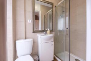 a bathroom with a toilet and a sink and a shower at Victória Guest House in Furnas +40 photos