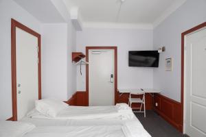 a hotel room with two beds and a desk at Hotell Skeppsbron in Stockholm