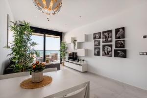 a living room with white walls and a large window at INFINITY View Amazing Beachfront Apartment in Arenales del Sol