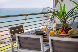 a table with a plate of fruit and a bottle of wine at INFINITY View Amazing Beachfront Apartment in Arenales del Sol