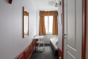 a bedroom with a bed and a desk and a mirror at Hotell Skeppsbron in Stockholm