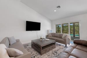 a living room with two couches and a flat screen tv at Poolside Sunset in South Gulf Cove in Port Charlotte +21 photos