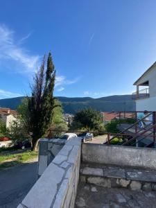a retaining wall next to a road with a house at Jardin in Igalo +10 photos
