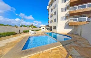 a swimming pool in front of a building at Apto Vista Impecável - Praia do Forte in Cabo Frio