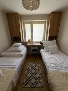 two beds in a room with a desk and a window at uDany w Goniądzu in Goniadz +17 photos