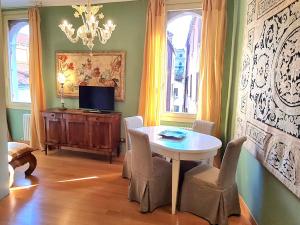 a dining room with a table and chairs and a television at Allegretto Rialto in Venice