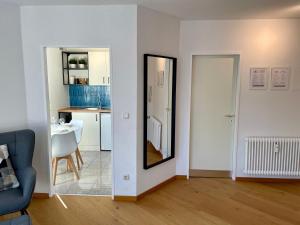 a living room with a mirror and a kitchen at VIBE Altstadt Apartments - Zentral - Sonnig - Voll ausgestattet in Mönchengladbach