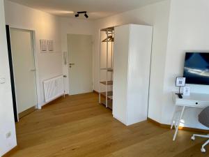 a living room with a desk and a tv at VIBE Altstadt Apartments - Zentral - Sonnig - Voll ausgestattet in Mönchengladbach +26 photos