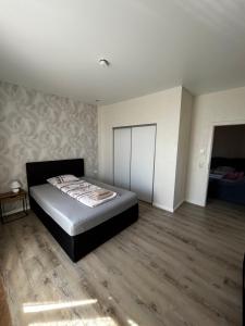 a bedroom with a bed and a wooden floor at Schöne 2 Zimmer Ferienwohnung mit WLAN Direkt an der Autobahn in Achim