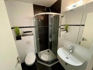a bathroom with a shower and a toilet and a sink at VIBE Altstadt Apartments - Zentral - Sonnig - Voll ausgestattet in Mönchengladbach