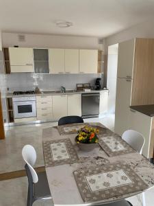 a kitchen with a table with a bowl of fruit on it at Madruzzo e Natura del Garda B&B in Lasino +14 photos