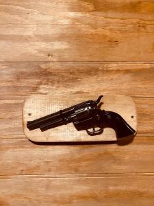a gun on a wooden board on a table at Western House Madrid Warner in San Martín de la Vega +13 photos