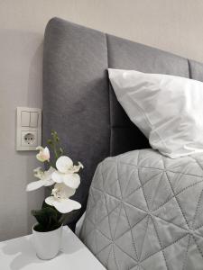 a bed with a pillow and white flowers on a table at Twin Stars in Drama