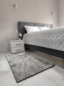 a bedroom with a bed with a nightstand and a rug at Twin Stars in Drama