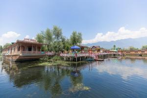 a resort with a pier and a boat on the water at Royal Mumtaz Grp 蒙達斯集團 in Srinagar