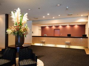 a waiting room with two chairs and a vase of flowers at Chisun Hotel Utsunomiya in Utsunomiya