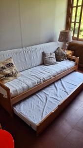 a large couch sitting in a room with a lamp at Chalet de caractère in Alex