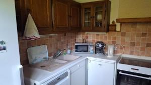 a kitchen with a sink and a microwave at Chalet de caractère in Alex