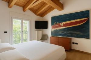 a bedroom with a bed and a painting of a boat at Ca Del Senior - Pool & Lake View in Mezzegra