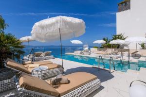 a swimming pool with lounge chairs and an umbrella at Gallery Luxury Suites & Rooms-Only Adults in Split